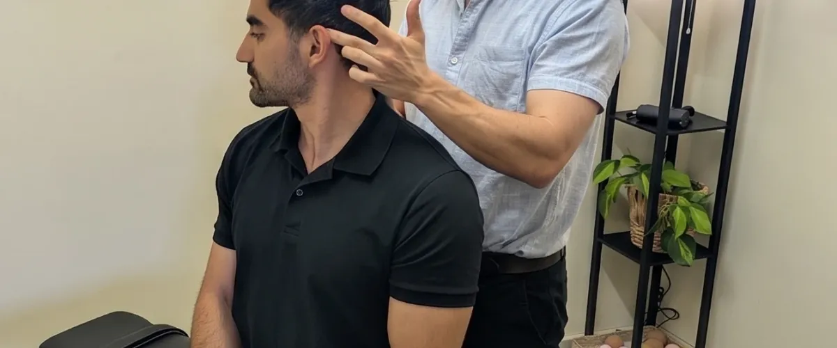 Dr Simon Hardy performing cervical range of motion assessment at Bassendean Chiropractic, Morley